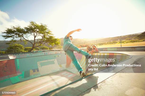 friends watching man perform skateboard trick at skate park - skateboard park stock pictures, royalty-free photos & images