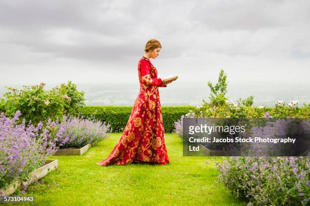 woman in medieval costume reading book in garden - atriz imagens e fotografias de stock