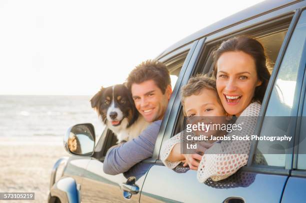 caucasian family in car windows on beach - happy family in car stock pictures, royalty-free photos & images