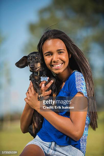 mixed race girl hugging dog outdoors - 13 year old girls in shorts stock pictures, royalty-free photos & images