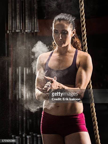 caucasian athlete chalking her hands in gym - sports chalk stock pictures, royalty-free photos & images