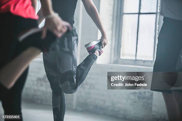 athletes stretching legs in gym - john hale stock pictures, royalty-free photos & images