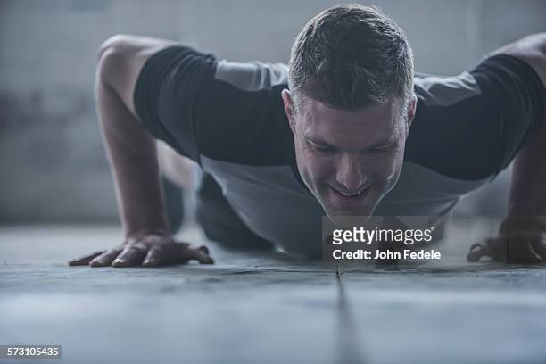 caucasian athlete doing push-ups on floor - surface preparation stock pictures, royalty-free photos & images