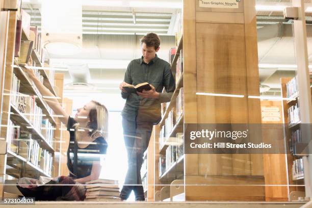 caucasian student reading books in library - two men studying library stock-fotos und bilder