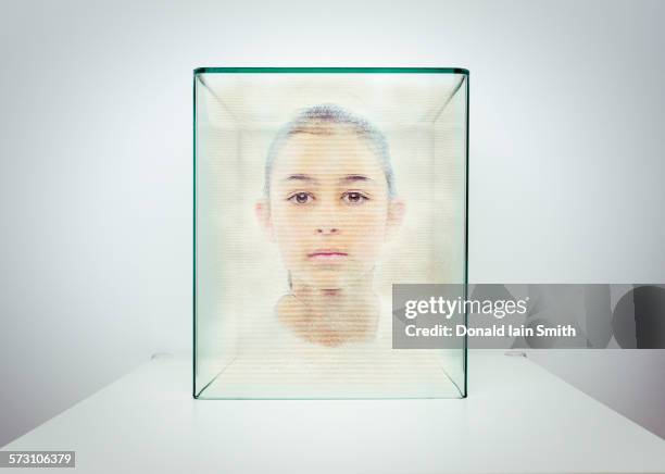 hologram of mixed race girl in glass box - glass box stockfoto's en -beelden