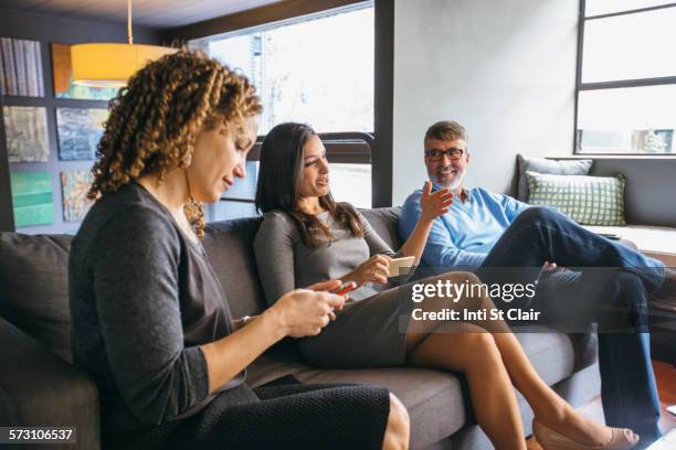 business people talking in office meeting - three people on couch stock pictures, royalty-free photos & images