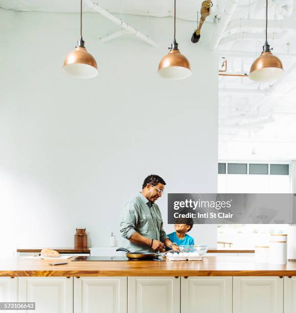 father and son cooking in kitchen - seattle home stock pictures, royalty-free photos & images