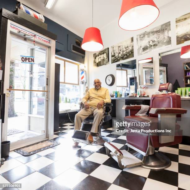 black barber smiling in retro barbershop - barber shop interior stock pictures, royalty-free photos & images