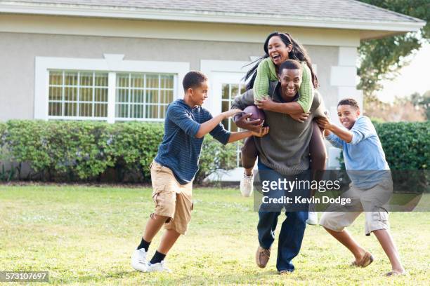 family playing football in backyard - saia florida stock-fotos und bilder