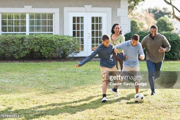 family playing soccer in backyard - football training stockfoto's en -beelden