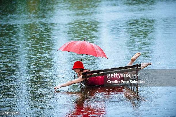 caucasian woman laying on bench in flood - women in see through dresses stock-fotos und bilder