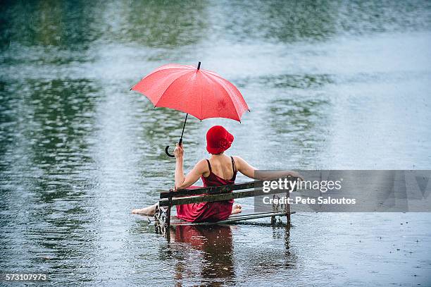 caucasian woman sitting on bench in flood - irony stock pictures, royalty-free photos & images