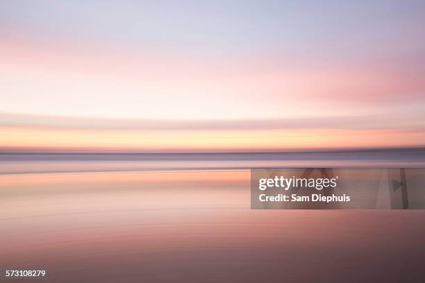 defocused view of ocean waves on beach under sunset sky - leaving california stock pictures, royalty-free photos & images