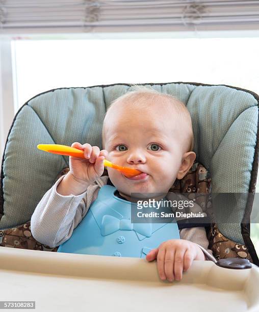 caucasian baby boy eating in high chair - babies and smoking stock-fotos und bilder