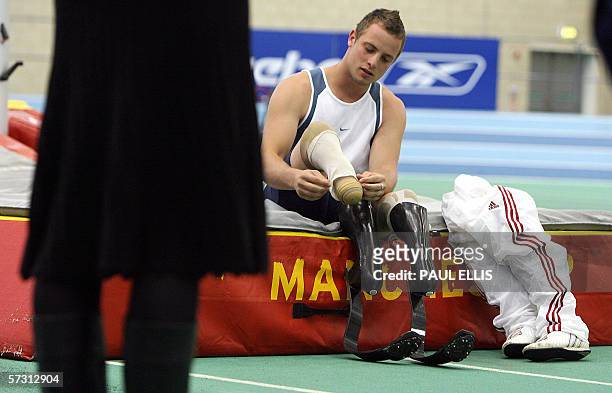Manchester, UNITED KINGDOM: South African Paralympic sprinter Oscar Pistorius prepares his 'blades' as he takes a coaching session with children at...