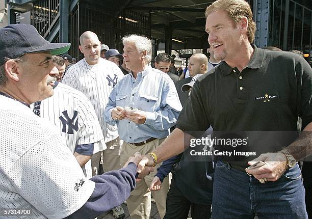 Baseball Hall of Famer Wade Boggs shakes hands with a fan as he hands out NYC Metro Cards outside Yankee Stadium before their home opener, April 11,...