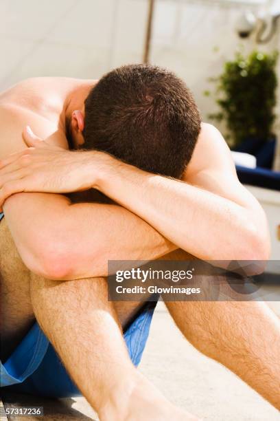 young man sitting at the poolside - foetushouding stockfoto's en -beelden