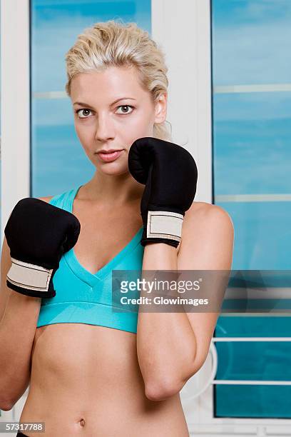portrait of a young woman wearing boxing gloves - belly punching stock pictures, royalty-free photos & images