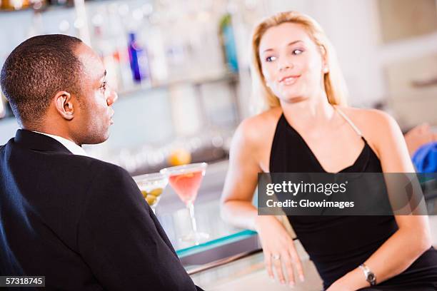 young couple sitting at a bar counter - cocktail counter stock pictures, royalty-free photos & images