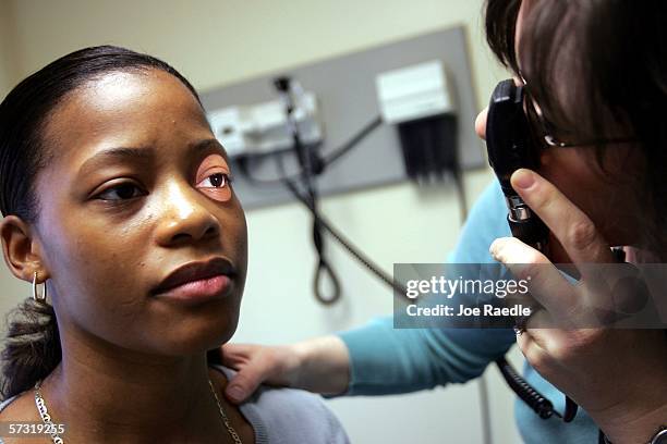 Dr. Elizabeth Maziarka looks through an instrument during an examination of patient June Mendez at the Codman Square Health Center April 11, 2006 in...