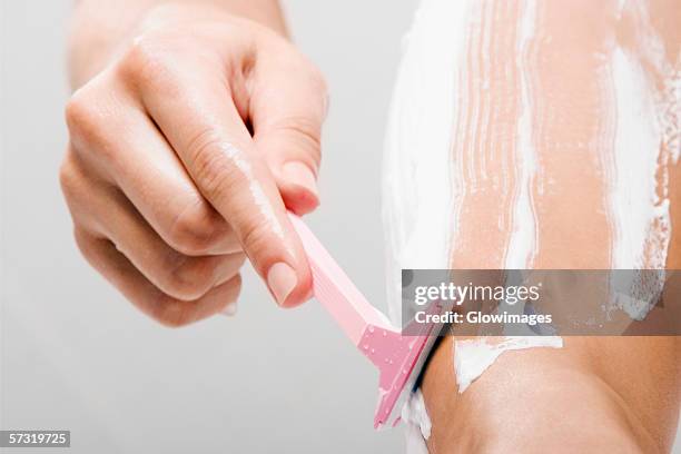 low section view of a woman shaving her leg with a razor - shaving cream stock-fotos und bilder