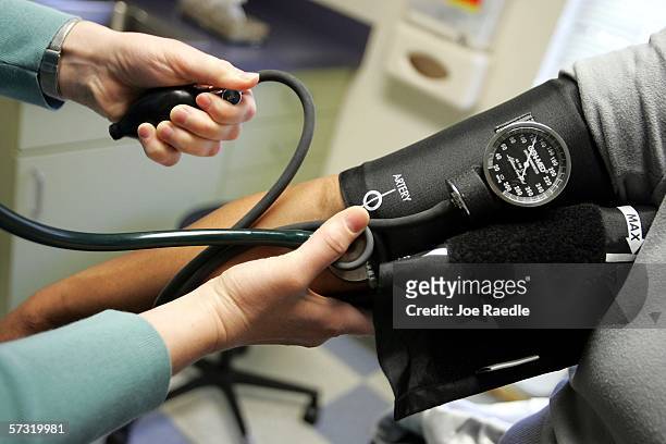 Dr. Elizabeth Maziarka reads a blood pressure gauge during an examination of patient June Mendez at the Codman Square Health Center April 11, 2006 in...