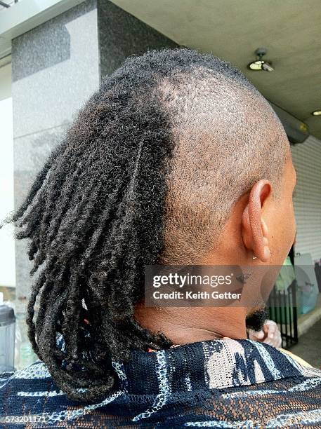 The visual contrast of the back of a woman's head with half of her hair shaved & half of her hair full - Fort Greene, Brooklyn, New York City July...