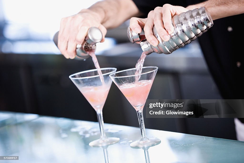 Close-up of a person's hand preparing a cocktail