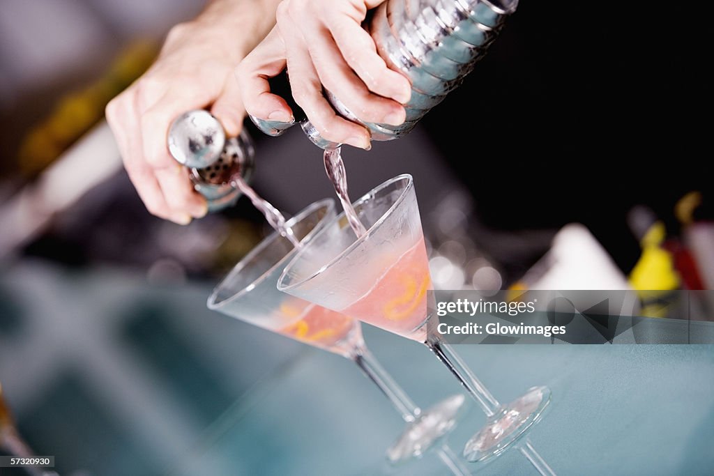 Close-up of a person's hand preparing a cocktail