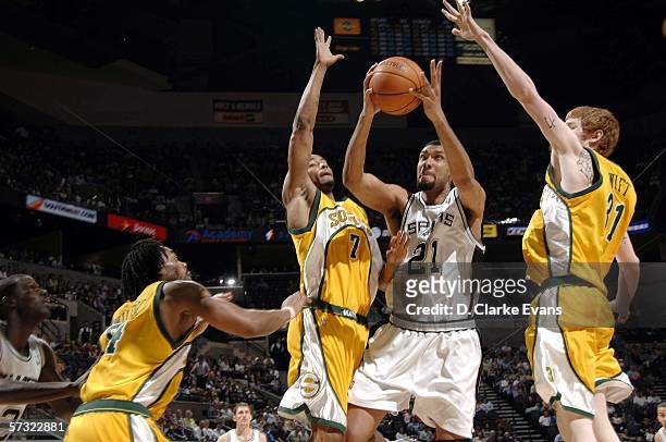 Tim Duncan of the San Antonio Spurs shoots between Rashard Lewis and Robert Swift of the Seattle SuperSonics on April 11, 2006 at the AT&T Center in...