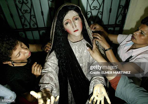 Tegucigalpa, HONDURAS: Two faithful women dress the image of Mary Magdalene 11 April, 2006 in the cathedral of Tegucigalpa, as part of the...