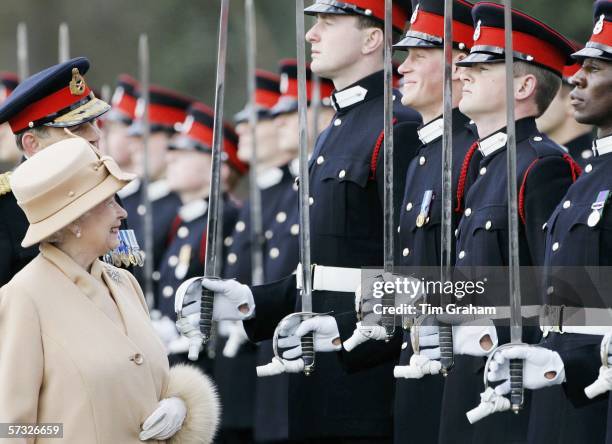 Queen Elizabeth II smiles at Prince Harry as she inspects soldiers at their passing-out Sovereign's Parade at Sandhurst Military Academy on April 12,...