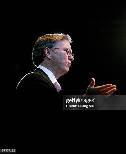 Google chief executive Eric Schmidt is seen through a stage curtain as he speaks during the inauguration of the company new Chinese brand name "Gu...