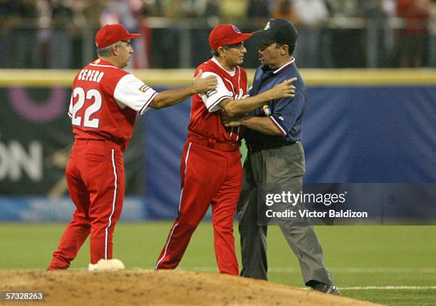 Manager Higinio Velez of Cuba is restrained by the umpire during a game against Puerto Rico on March 15, 2006 at Hiram Bithorn Stadium in San Juan,...