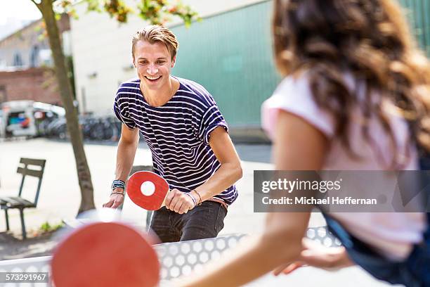 young couple playing table tennis - tafeltennis stockfoto's en -beelden