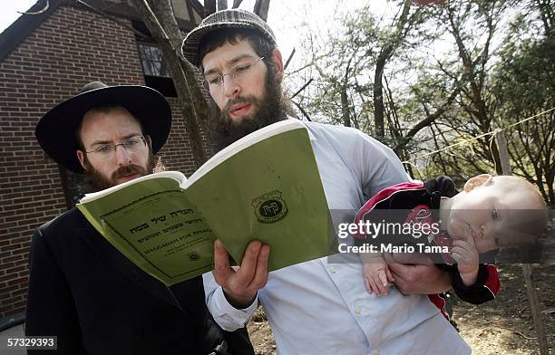 Lubavitch Hasidic reggae singer Matisyahu holds his son Laivy with Lubavitch rabbi Simcha Levenburg while reading a prayer during the "biur chametz"...