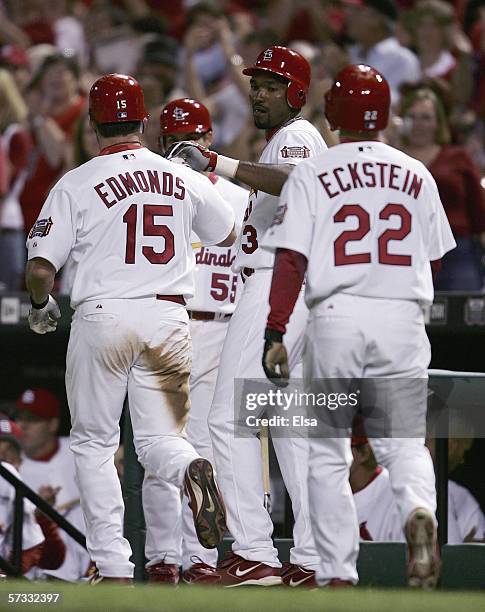 Jim Edmonds of the St. Louis Cardinals celebrates with teammates Juan Encarnacion and David Eckstein after Edmonds hit a three-run double and scored...