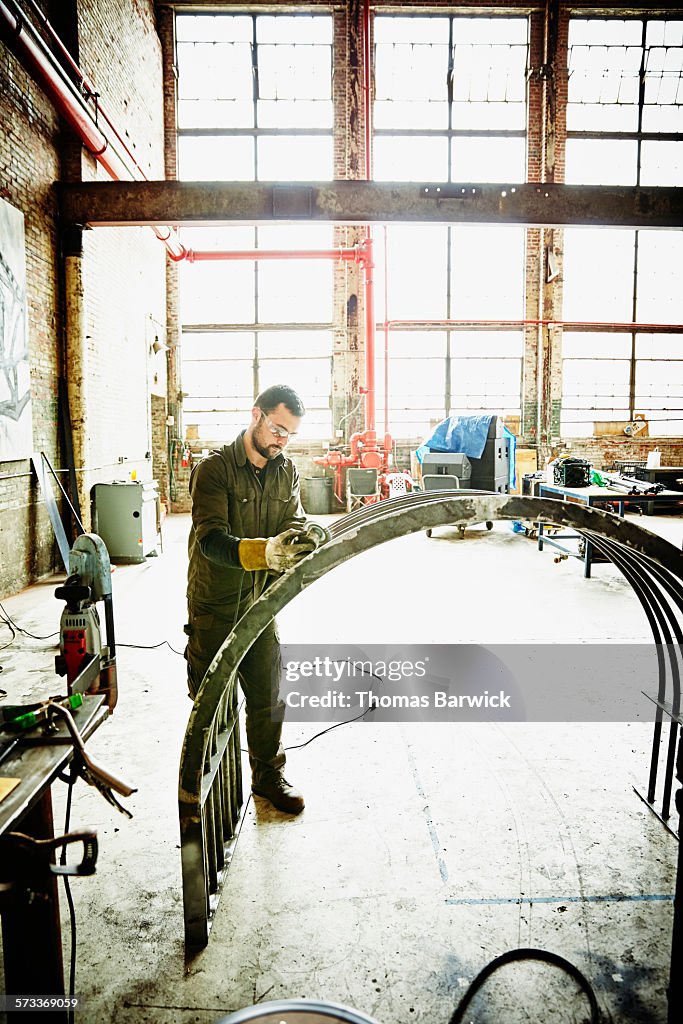 Metal worker using angle grinder to polish project