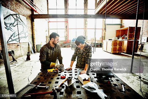 metal shop owner in discussion with apprentice - polishing metal stock pictures, royalty-free photos & images