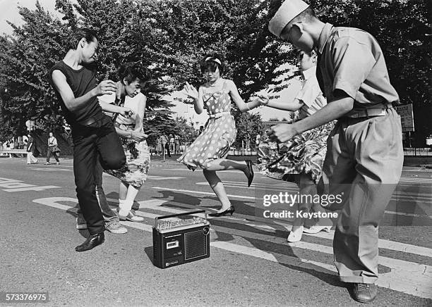 Teenagers dance the twist around a radio cassette recorder in a street in the Harajuku district of Shibuya, Tokyo, Japan, 1978.