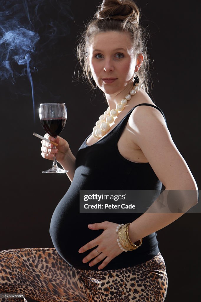 Pregnant woman drinking wine and smoking