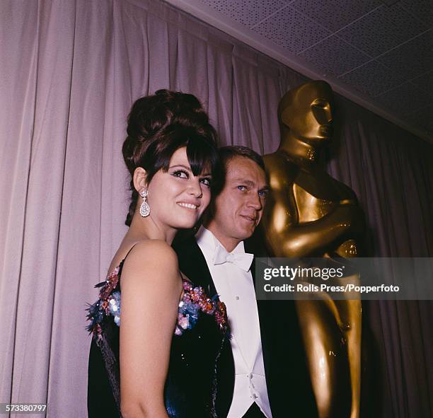 Italian actress Claudia Cardinale pictured with American actor Steve McQueen at the 37th Academy Awards or Oscars at the Santa Monica Civic...