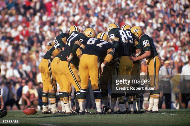 Members of the Green Bay Packers football team huddle together to discuss their next play during Super Bowl I against the Kansas City Chiefs at...