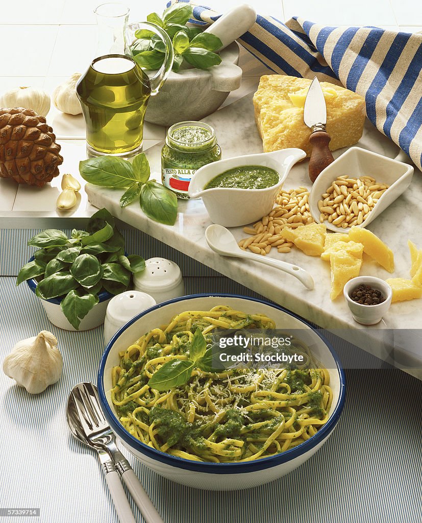 High angle view of a bowl of pasta served on a table with condiments and cheeses