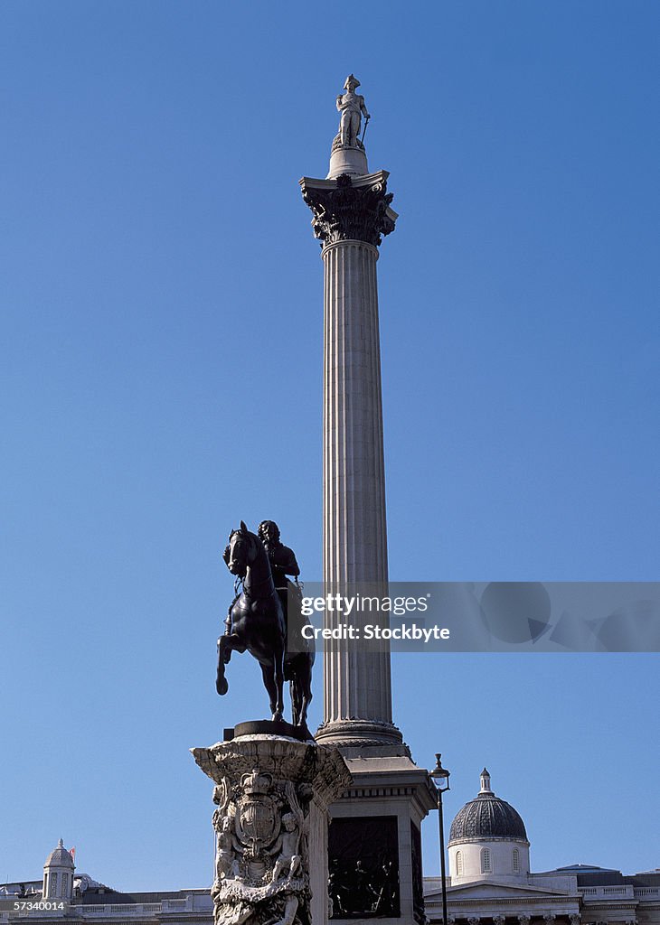 A statue of a man riding a horse and a carved column