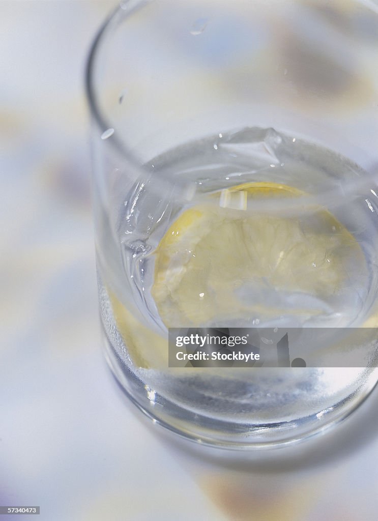 Close-up of a glass of ice water and a slice of lemon