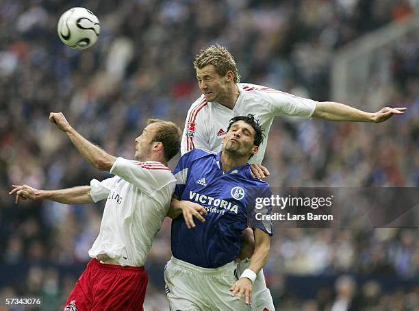 Kevin Kuranyi of Schalke goes up for a header with Carsten Cullmann and Lukas Sinkiewicz of Cologne during the Bundesliga match between Schalke 04...