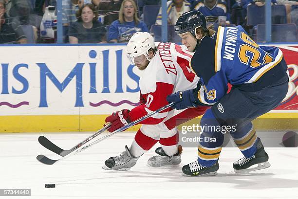Henrik Zetterberg of the Detroit Red Wings and Jeff Woywitka of the St. Louis Blues chase after the puck on April 15, 2006 at the Savvis Center in...