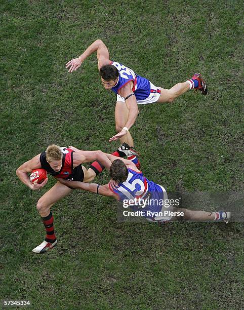 Adam McPhee of the Bombers is tackled by Sam Power of the Bulldogs during the round three AFL match between the Essendon Bombers and the Western...