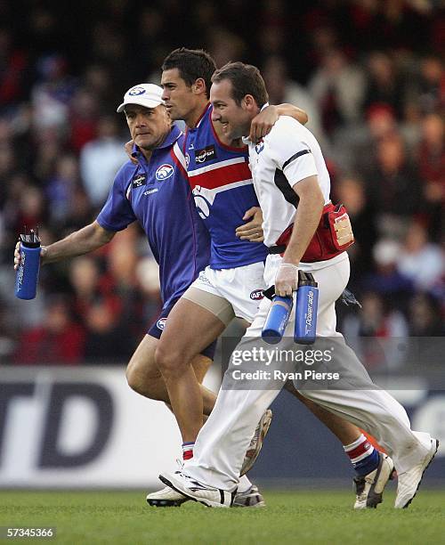 Daniel Giansiracusa of the Bulldogs leaves the ground after injuring his leg during the round three AFL match between the Essendon Bombers and the...